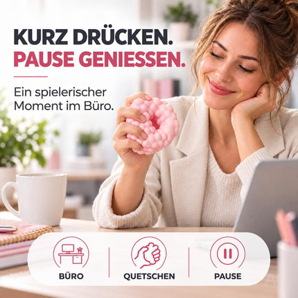 Pinker Knetball beim Drücken während einer Pause am Schreibtisch